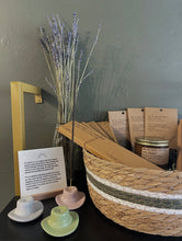 Load image into Gallery viewer, Cowboy hat incense holder and decorative items including a basket, candles, and lavender on a dark surface with a gray wall background.
