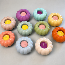 Load image into Gallery viewer,  Ten pastel pumpkin-shaped tea light candle holders in purple, mint, sage, blush, olive green, yellow, orange, coral, white, and powder blue with colorful tea lights arranged in a loose flat lay on a gray surface
