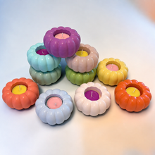 Load image into Gallery viewer, en pastel pumpkin-shaped tea light candle holders in purple, mint blue, sage, blush, green, yellow, orange, coral, white, and powder blue with colorful tea lights, stacked and grouped on a light blue-white gradient surface
